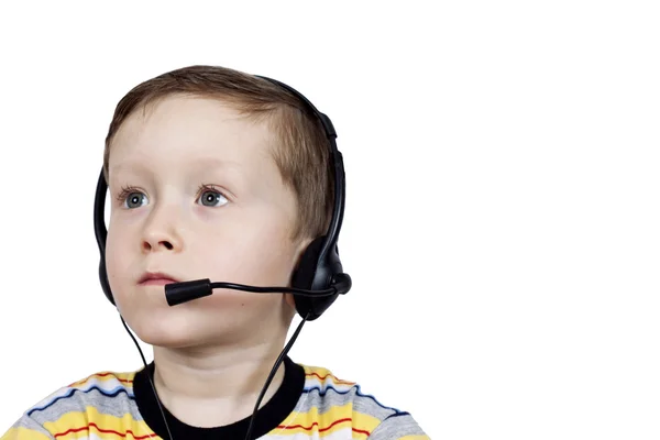 Ένα μικρό αγόρι που σκέφτεται τα ακουστικά με μικρόφωνο — Φωτογραφία Αρχείου