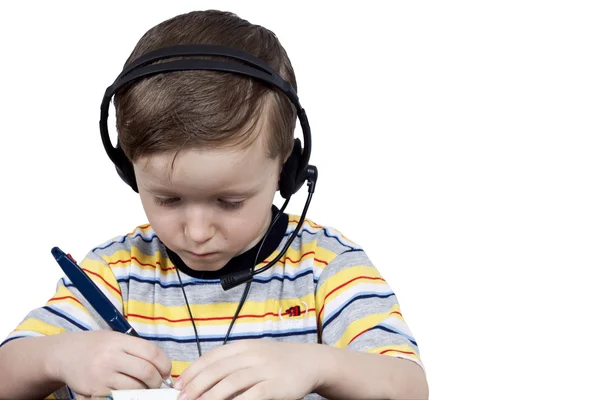 Malý kluk si myslí, že sluchátka s mikrofonem — Stock fotografie