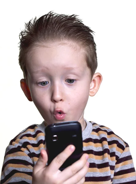 O menino ficou surpreso ao olhar no telefone — Fotografia de Stock