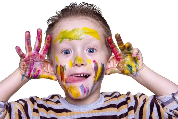 A happy little boy with a cute face smeared with paint — Stock Photo, Image