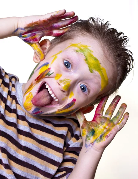 A happy little boy with a cute face smeared with paint — Stock Photo, Image