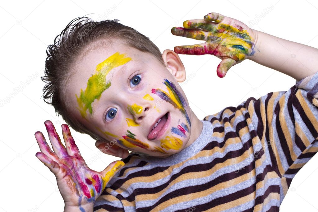 A happy little boy with a cute face smeared with paint