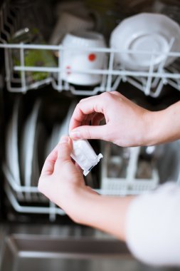 Ev işi: Bulaşık makinesine bulaşık koyan genç bir kadın
