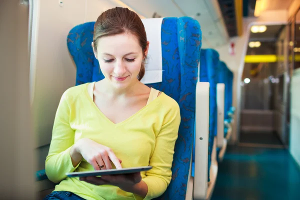 Mladá žena pomocí její tabletový počítač při cestování vlakem — Stock fotografie