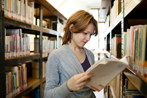 Pretty female college student in a llibrary (color toned image) — Stock Photo, Image