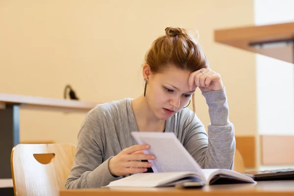 Estudiante universitaria bastante femenina en una biblioteca (imagen tonificada en color ) — Foto de Stock