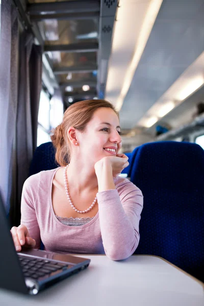 Ung kvinna med hennes bärbara dator medan på tåget (shallo — Stockfoto