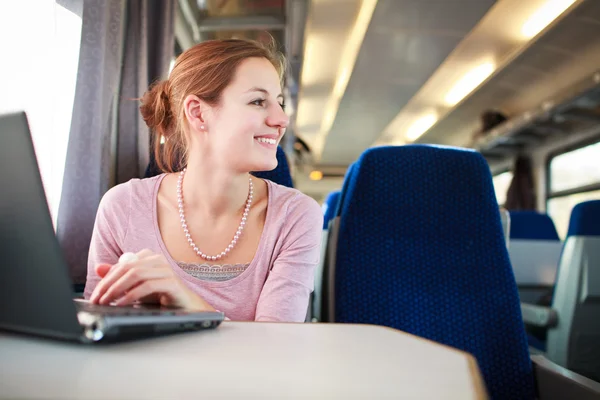 Jovem mulher usando seu computador portátil enquanto no trem (shallo — Fotografia de Stock