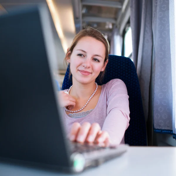 Jovem mulher usando seu computador portátil enquanto no trem (shallo — Fotografia de Stock