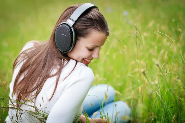 Portret van een mooie jonge vrouw luisteren naar muziek — Stockfoto