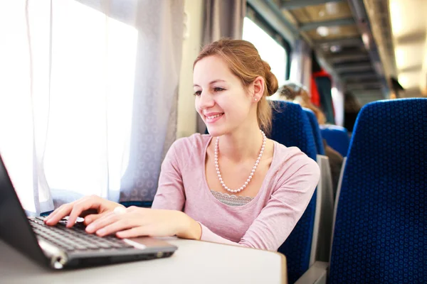 Mladá žena pomocí její přenosný počítač ve vlaku (shallo — Stock fotografie