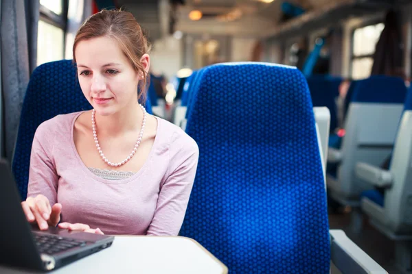 Jovem mulher usando seu computador portátil enquanto no trem (shallo — Fotografia de Stock