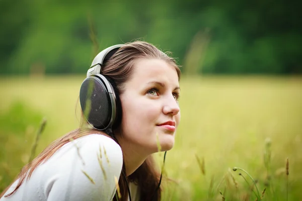 Портрет красивої молодої жінки, що слухає музику на її mp3 p — стокове фото