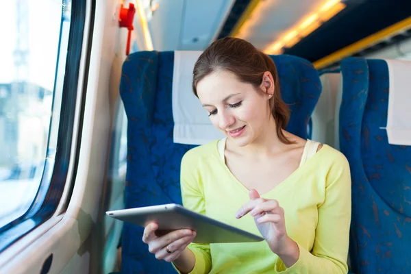 Young woman using her tablet computer while traveling by train Royalty Free Stock Images