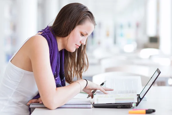 Ganska kvinnliga collegestudent som studerar på bibliotek — Stockfoto