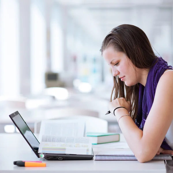 Vrij vrouwelijke college student studeert in de Universiteitsbibliotheek — Stockfoto