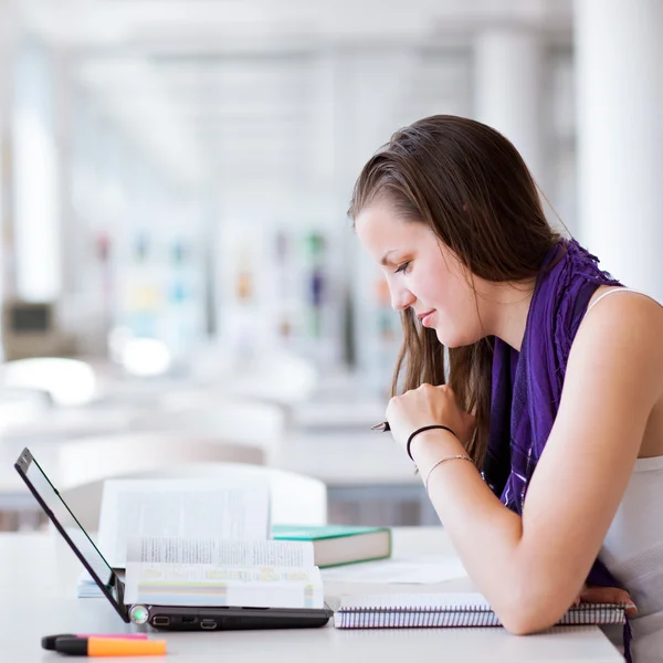Ganska kvinnliga collegestudent som studerar på bibliotek — Stockfoto