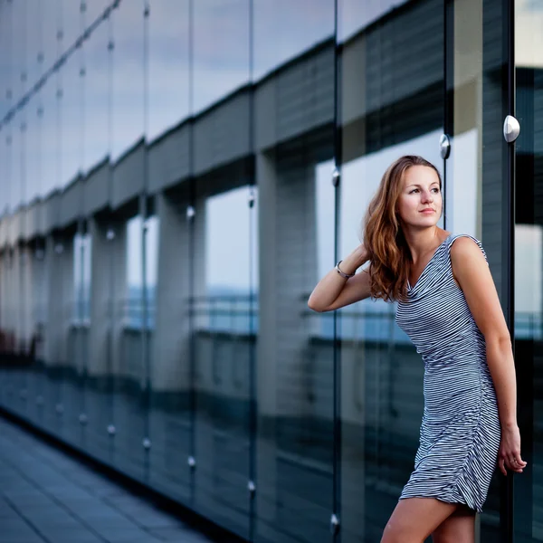 Fiatal nő pózol egy felső a modern építészet épületébe — Stock Fotó