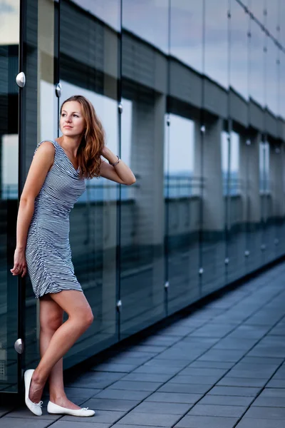 Junge Frau posiert in einem modernen Gebäude der Spitzenarchitektur — Stockfoto