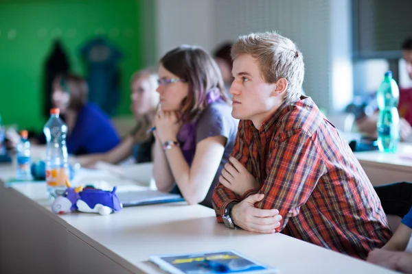 Молодий, красивий студент коледжу сидить у класі — стокове фото