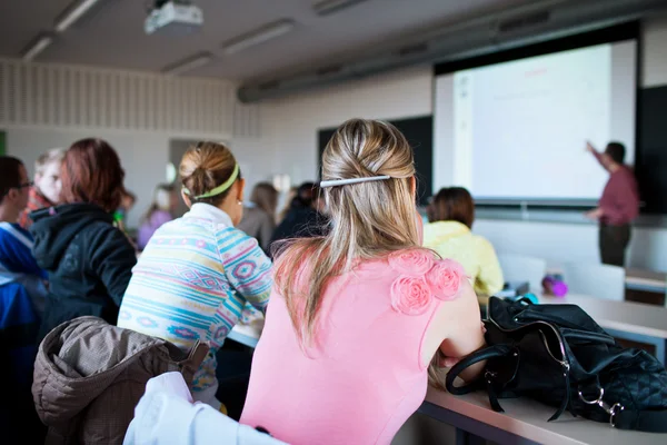 Jovem, estudante universitário muito feminino sentado em uma sala de aula — Fotografia de Stock