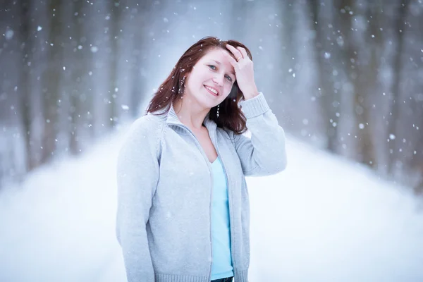 Den ersten Schnee genießen: junge Frau im Freien — Stockfoto