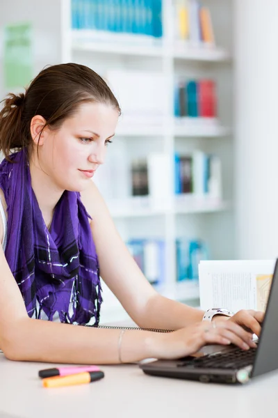 Estudiante universitaria bastante femenina estudiando en la biblioteca universitaria —  Fotos de Stock