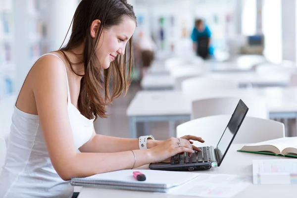 Jolie étudiante qui étudie à la bibliothèque de l'université — Photo