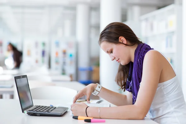 Vrij vrouwelijke college student studeert in de Universiteitsbibliotheek — Stockfoto