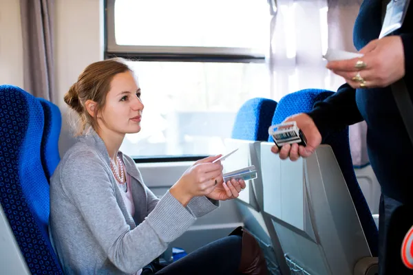 Frau lässt ihr Ticket vom Zugbegleiter überprüfen — Stockfoto
