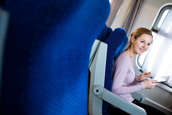 Jonge vrouw met behulp van haar tablet-pc terwijl het reizen met de trein — Stockfoto