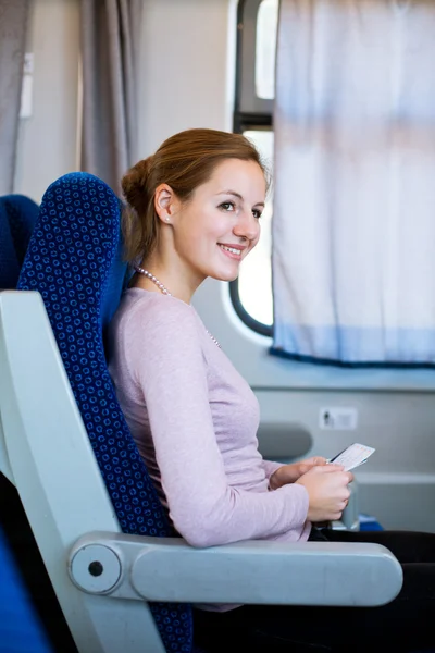 Mujer joven viajando en tren, sosteniendo su billete de tren — Foto de Stock