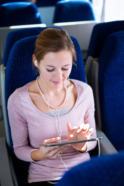 Trenle seyahat ederken onun tablet bilgisayar kullanan genç kadın — Stok fotoğraf