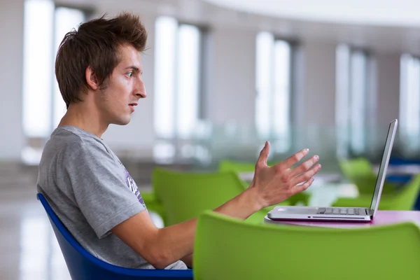 Högskolestudent som använder sin bärbara dator — Stockfoto