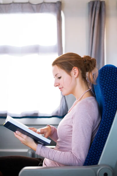 Молода жінка читає книгу в потязі — стокове фото