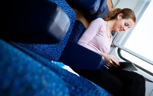 Νεαρή γυναίκα διαβάζοντας ένα βιβλίο, ενώ σε ένα τρένο — Φωτογραφία Αρχείου