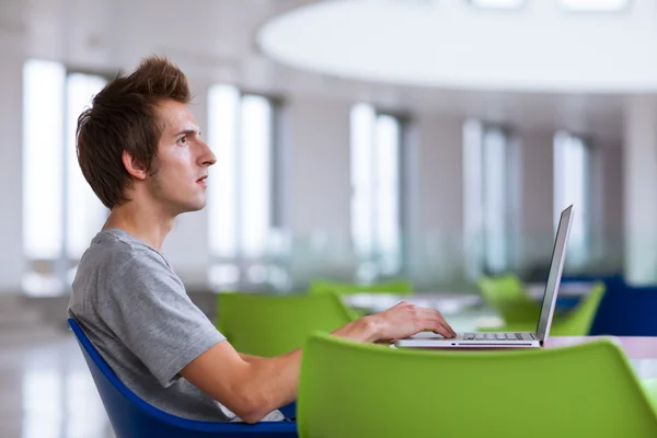 Estudante universitário usando seu computador portátil — Fotografia de Stock