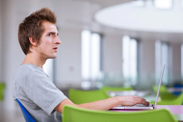 Estudante universitário usando seu computador portátil — Fotografia de Stock