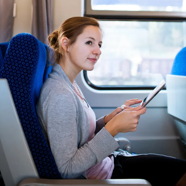 Młoda kobieta za pomocą jej komputer typu tablet, podczas podróży pociągiem — Zdjęcie stockowe