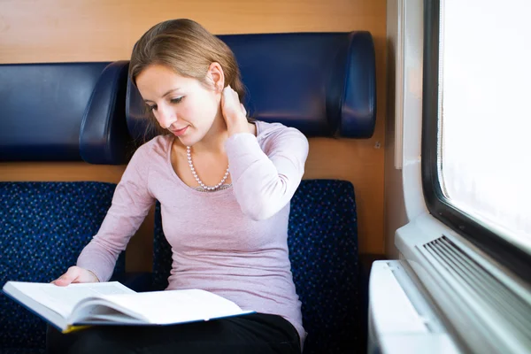 Fiatal nő Olvasson egy könyvet a vonaton — Stock Fotó