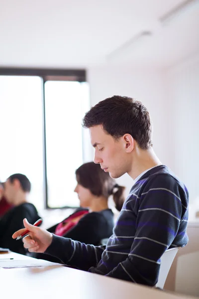 Jeune, beau étudiant masculin assis dans une salle de classe — Photo