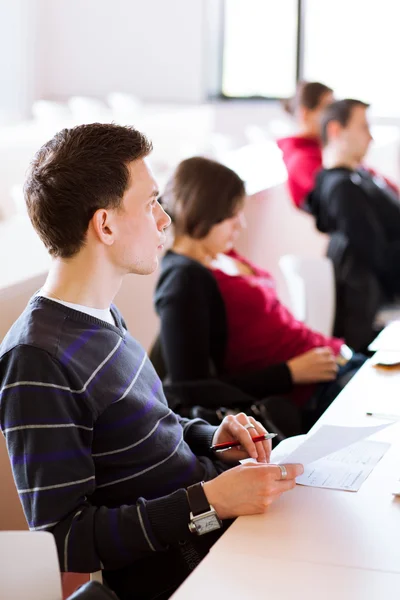 Young, handsome male college student sitting in a classroom — Stock Photo, Image