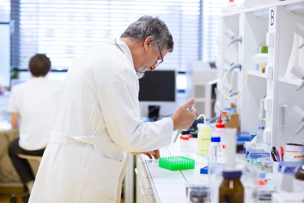 Старший исследователь-мужчина проводит научные исследования в лаборатории — стоковое фото