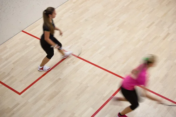 Duas jogadoras de squash em ação rápida em uma quadra de squash — Fotografia de Stock