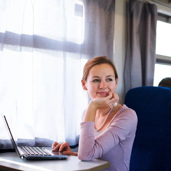 젊은 여자는 기차를 하는 동안에 그녀의 노트북 컴퓨터를 사용 하 여 — 스톡 사진