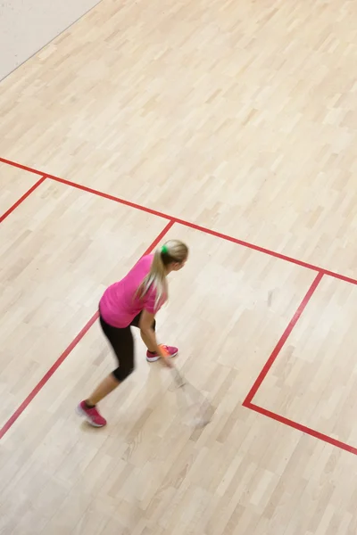 Två kvinnliga squash spelare i snabb action på en squashbana — Stockfoto