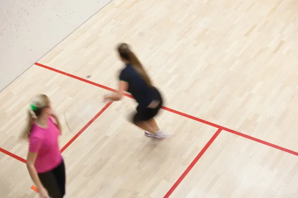 Dva ženské squashové hráče v rychlých akcí na squashovém kurtu — Stock fotografie