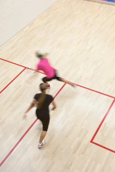 两个女性壁球运动员在上一个壁球场快速行动 — 图库照片