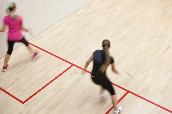 两个女性壁球运动员在上一个壁球场快速行动 — 图库照片