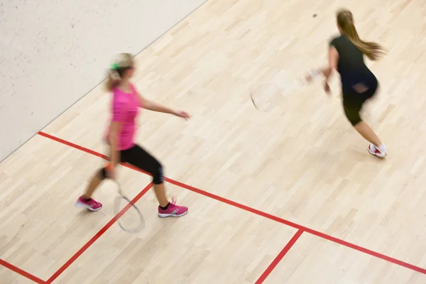 Deux joueuses de squash en action rapide sur un court de squash — Photo